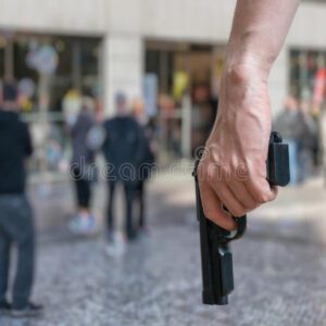 a man wearing jeans and holding a gun